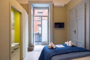 een slaapkamer met een bed en een badkamer met een raam bij B&B o' Panar al Duomo in Napels