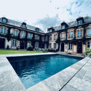 a large house with a swimming pool in front of it at Maison d'hôtes l'Évidence in Rugles