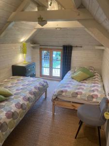 a bedroom with two beds in a attic at Le Nid de Bercé in Jupilles