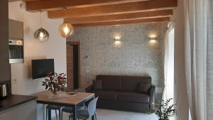 a living room with a couch and a table at GARDA BALDO APARTMENTS_VIVALDI in Nago-Torbole
