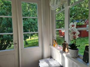 a room with a window with a flower on a ledge at Trevligt Torp i vacker natur in Mellerud