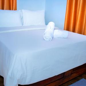 een bed met twee rollen handdoeken erop bij Cambric Luxe Studio Apartment in Kilifi