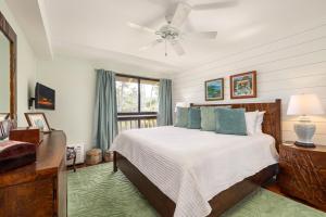 a bedroom with a bed and a ceiling fan at Spectacular golf course front in Kahuku