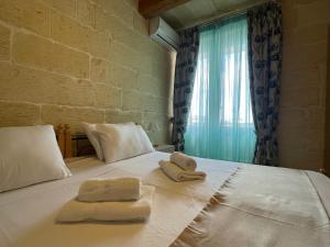1 dormitorio con toallas en una cama con ventana en San Antonio 71, en Victoria