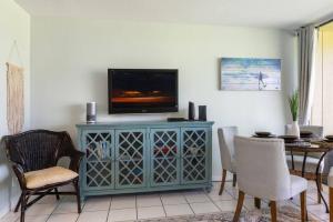 a living room with a television on top of a cabinet at Gorgeous One Bedroom golf course front in Kahuku