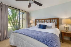 a bedroom with a large bed with blue and white sheets at Gorgeous One Bedroom golf course front in Kahuku