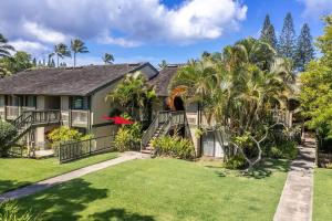 a house with palm trees and a yard at Gorgeous One Bedroom golf course front in Kahuku