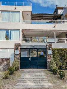 a building with a green garage door with the number at Aqualina Suites in Valeria del Mar