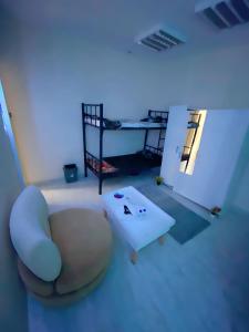 uma sala de estar com uma cadeira e uma mesa em MBZ - Nice Bed Space "MEN" em Abu Dhabi