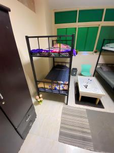 MBZ - Nice Bed Space "MEN" في أبوظبي: غرفة بسريرين بطابقين وطاولة