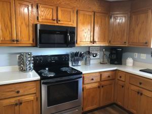 a kitchen with wooden cabinets and a stove top oven at Beautiful Farmhouse near Atlanta's Airport! in Atlanta