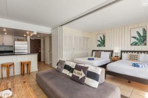 sala de estar con 2 camas y sofá en Ocean Front Amazing One bedroom condo, en Honolulu