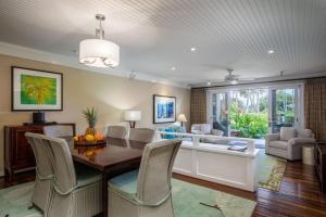 a living room with a dining room table and chairs at Glorious Beachfront high end Villa in Kahuku