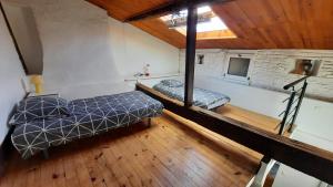 Cette chambre mansardée comprend 2 lits et une télévision. dans l'établissement PROMO 27-31 mai Toulouse 15 mn appart 3 lits propre cuisine sde 4 personnes, à Montastruc-la-Conseillère