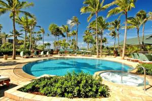 a pool at a resort with palm trees at Glorious Beachfront high end Villa in Kahuku