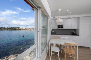 a kitchen with a large window overlooking the water at Apartamentos Rotilio in Sanxenxo