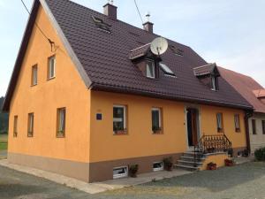 a large yellow house with a brown roof at Apartmani Lucija in Vrata