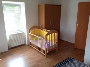 a baby room with a crib and a window at Apartmani Lucija in Vrata