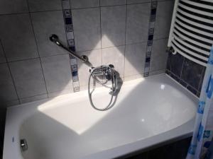 bañera blanca con percha en la pared en Apartmani Lucija en Vrata