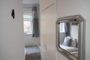 a mirror on a wall next to a bedroom at Hurley House in Cheadle Hulme
