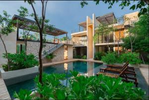 a house with a swimming pool in front of it at Cozy Ground and Terrace in La Veleta 2BR 4 Guests in Tulum