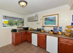 a kitchen with wooden cabinets and a counter top at Americas Best Value Inn Bradenton-Sarasota in Bradenton