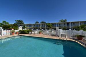 ein großer Pool mit Stühlen und ein Gebäude in der Unterkunft Americas Best Value Inn Bradenton-Sarasota in Bradenton