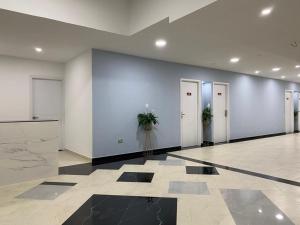 a lobby with white walls and doors with potted plants at Hotel Barranquilla Laank in Barranquilla