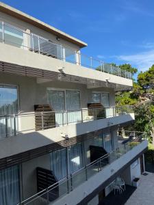 een gebouw met een balkon met stoelen erop bij Aqualina Suites in Valeria del Mar