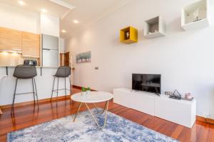 eine Küche und ein Wohnzimmer mit einem Tisch und einem TV in der Unterkunft Luxury Loft, Centro in Vigo