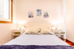 ein Schlafzimmer mit einem großen weißen Bett mit zwei Nachttischen in der Unterkunft Luxury Loft, Centro in Vigo