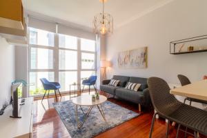 ein Wohnzimmer mit einem Sofa, einem Tisch und Stühlen in der Unterkunft Luxury Loft, Centro in Vigo