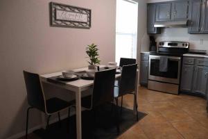 una cocina con mesa con sillas y una cocina con muebles de madera en Cozy 2-Bedroom Rental Unit, en Eagle Pass