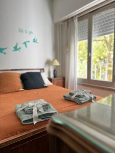 1 dormitorio con 1 cama con toallas y ventana en El departamento de la abuela en Mar del Plata