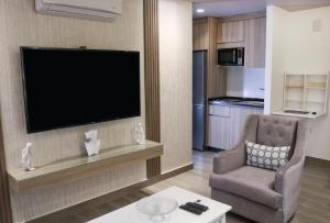 a living room with a television and a chair at Red Carpet Hotel & Suites in Amman