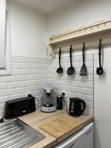 a kitchen counter with utensils hanging on a wall at Maureillas - appartement 2 personnes - classé in Maureillas +4 photos