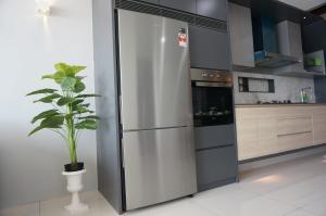 a stainless steel refrigerator in a kitchen with a potted plant at Seaview Duplex Sunrise Gurney 2BR 一级棒海景の楼中楼 in George Town