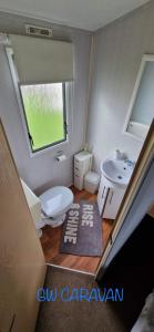 a small bathroom with a toilet and a sink at Whitehouse Leisure Park North wales 6 birth caravan in Kinmel Bay