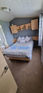 um quarto com uma cama com as palavras cu caravan em Whitehouse Leisure Park North wales 6 birth caravan em Kinmel Bay