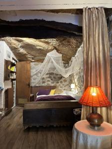 a bedroom with a bed with a stone wall at CASA NOTARI - Casa Rural Zona Congost de Montrebei in Tolva