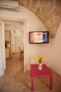 a living room with a table and a tv on the wall at Campo Appartamenti in Trapani