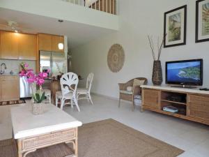 a living room with a television and a dining room at Spacious Townhouse by the beach in Kahuku