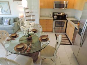 a kitchen with a glass table and chairs in a room at Spacious Townhouse by the beach in Kahuku