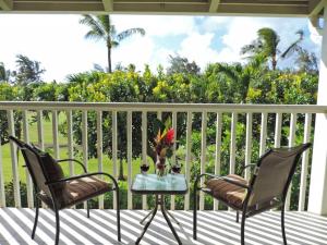 a patio with two chairs and a table on a porch at Spacious Townhouse by the beach in Kahuku