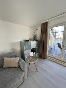a living room with a couch and a glass table at Schlösschen am Schmachter See in Binz