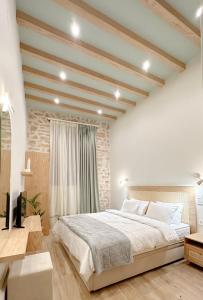 1 dormitorio con 1 cama grande y pared de ladrillo en Celestia Home, en Ioannina