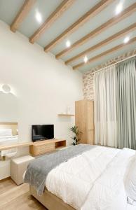 1 dormitorio con 1 cama grande y TV en Celestia Home, en Ioannina