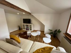 a living room with a white couch and two tables at Ferienwohnungen Am Schloss - Monteurzimmer Reuhl in Ernsthofen