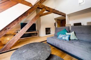 un soggiorno con divano e TV di Le SeptQatre - Grand triplex au cœur de la Vieille Ville ad Annecy