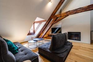 un soggiorno con divano e camino di Le SeptQatre - Grand triplex au cœur de la Vieille Ville ad Annecy